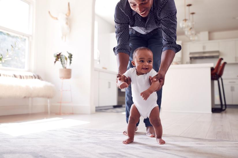 Image of parent helping baby walk