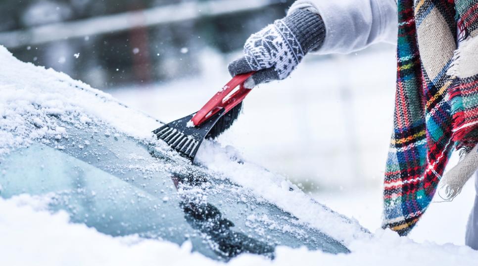 Cold weather with someone de-icing their car windscreen