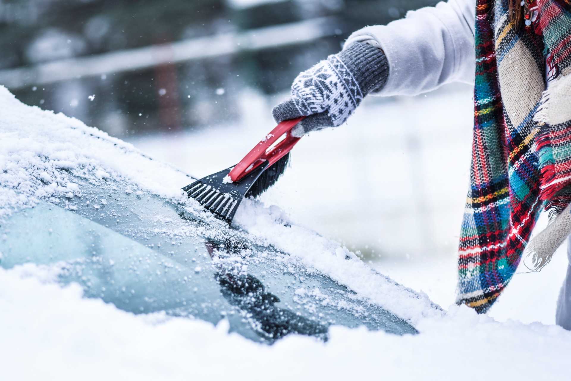 Cold weather with someone de-icing their car windscreen
