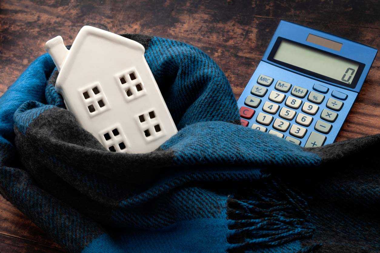 Image of a calculator & a ceramic piggy bank in the shape of a house