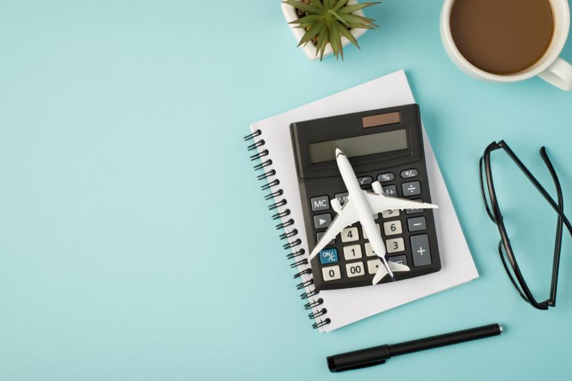 A toy plane sat on top of a calculator and notepad