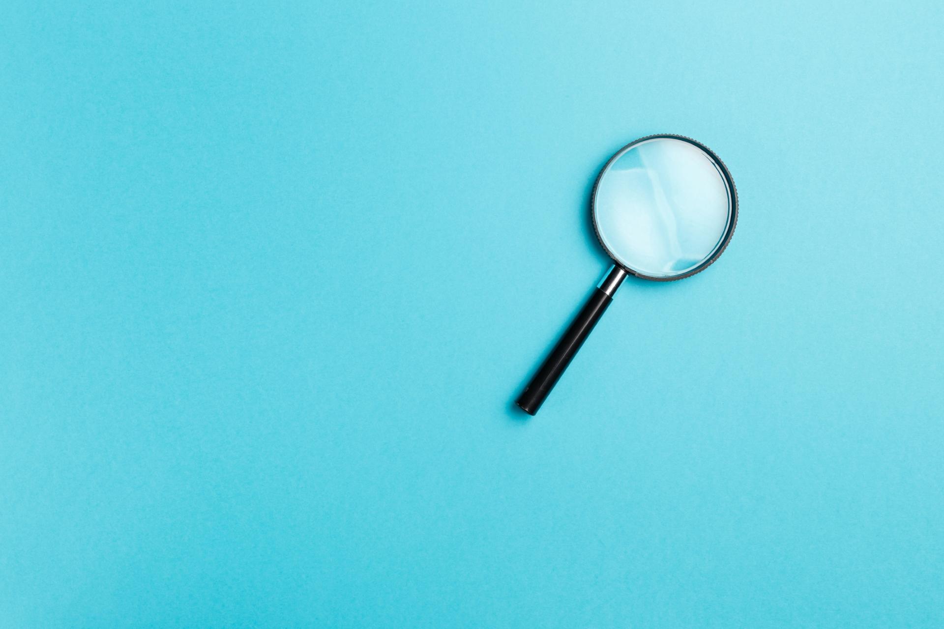 Magnifying glass on blue background