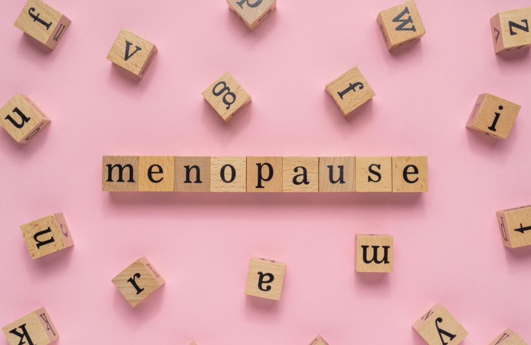 Scrabble titles spelling menopause on a pink background
