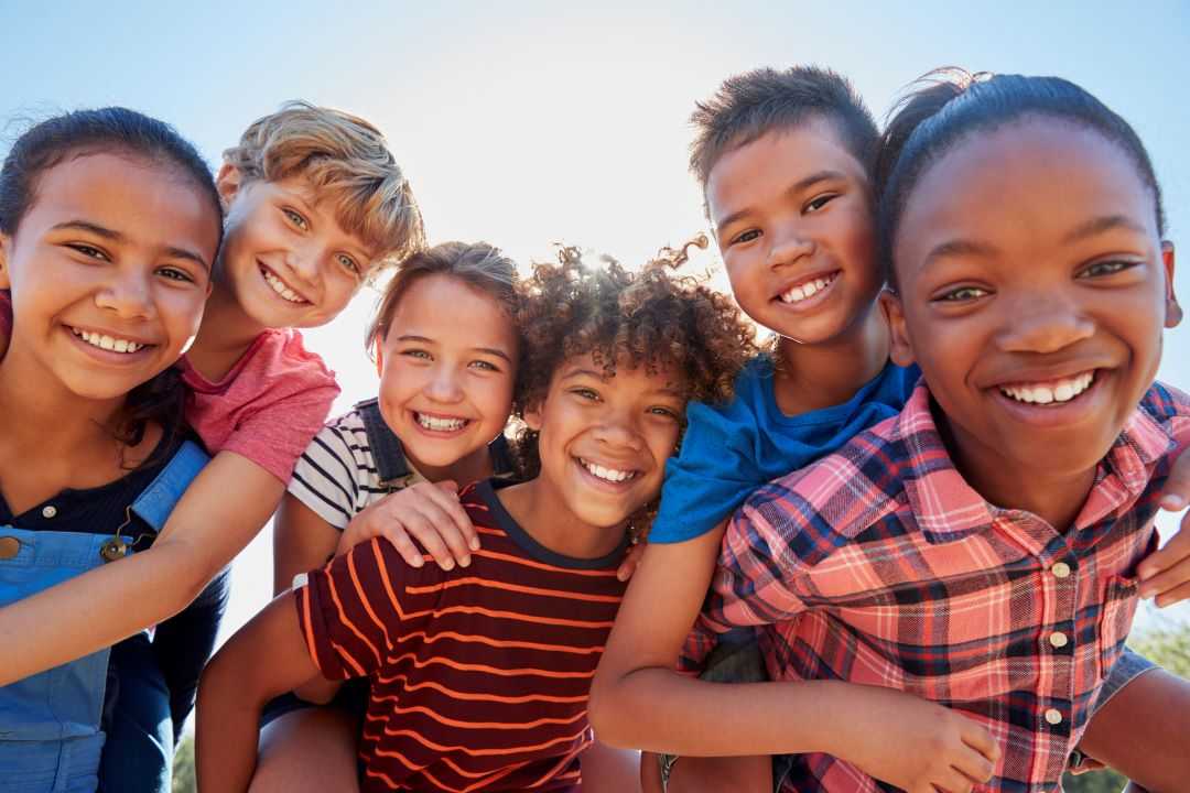 Image of 6 smiling children huddled together